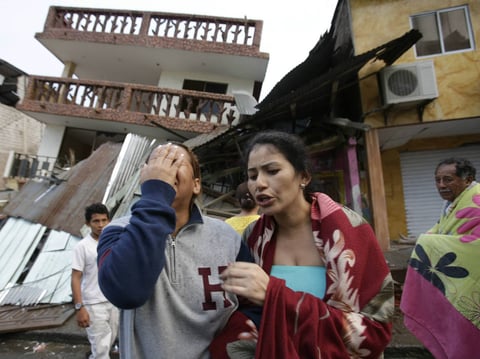A woman cries as she stands next to a house destroyed by the earthquake in the Pacific coastal town of Pedernales, Ecuador on Sunday. 